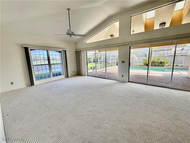 carpeted spare room with high vaulted ceiling and ceiling fan