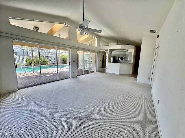 unfurnished living room featuring visible vents, light carpet, high vaulted ceiling, and ceiling fan