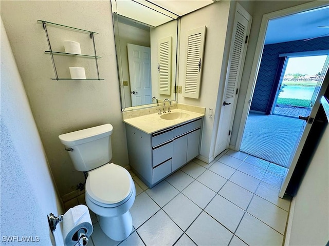 bathroom featuring baseboards, toilet, vanity, and tile patterned flooring