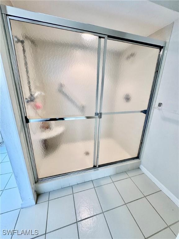 full bath with a stall shower and tile patterned flooring