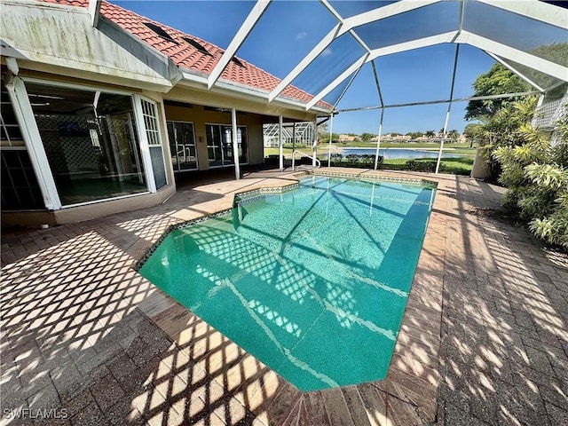 outdoor pool featuring a patio, a water view, and a lanai