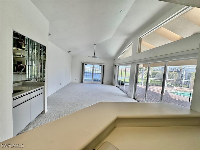 unfurnished room with ceiling fan, vaulted ceiling, and light carpet