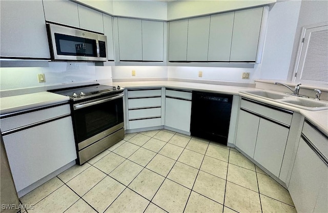 kitchen featuring light countertops, light tile patterned floors, appliances with stainless steel finishes, and a sink