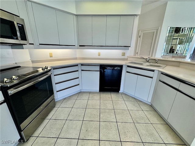 kitchen with a sink, stainless steel appliances, light tile patterned floors, and light countertops