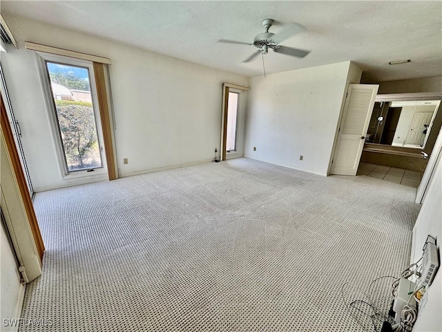 empty room featuring a textured ceiling, a ceiling fan, and light carpet