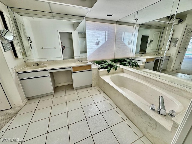 bathroom with tile patterned floors, a bath, and vanity