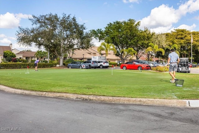 11730 Quail Village Way Unit 103-1, Naples, FL 34119 - view of property's community featuring uncovered parking, a putting green, a yard, and view of golf course