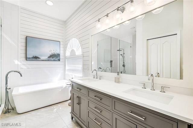 bathroom featuring double vanity, a freestanding tub, a shower stall, and a sink