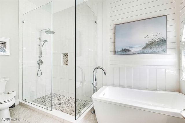 bathroom featuring toilet, a stall shower, and a freestanding bath