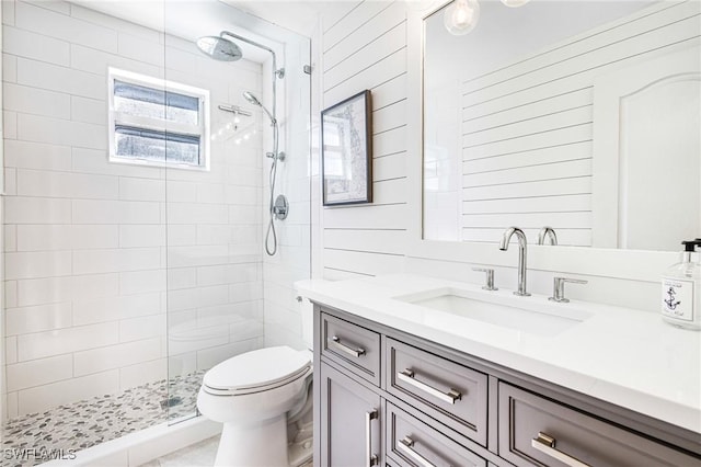 full bath with toilet, tiled shower, and vanity