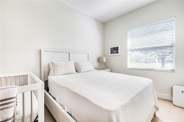 bedroom featuring light tile patterned floors and baseboards