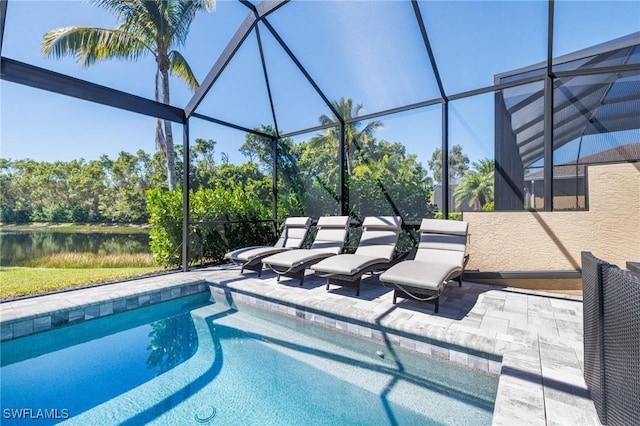 outdoor pool featuring a water view, a patio area, and glass enclosure