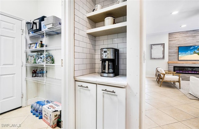 kitchen with light tile patterned floors, decorative backsplash, open floor plan, white cabinetry, and open shelves