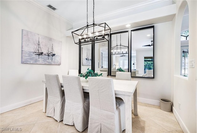 dining space with baseboards, visible vents, arched walkways, tile patterned flooring, and crown molding