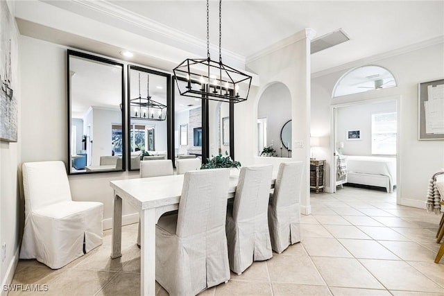 dining area featuring a notable chandelier, light tile patterned flooring, baseboards, and crown molding