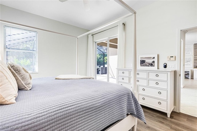 bedroom with wood finished floors and access to exterior