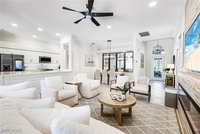 tiled living area with crown molding, a fireplace, recessed lighting, visible vents, and a sink