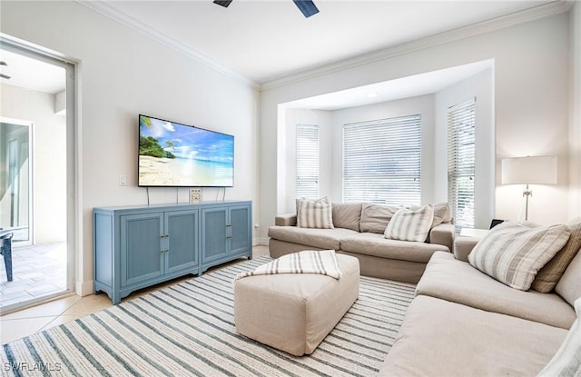 living area with a ceiling fan, light tile patterned flooring, ornamental molding, and baseboards