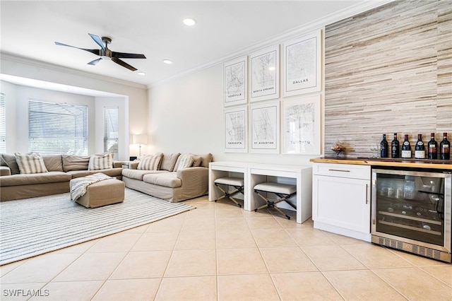 living area with light tile patterned floors, wine cooler, ornamental molding, and a dry bar