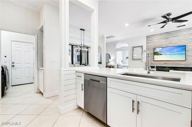 kitchen featuring ceiling fan, light tile patterned flooring, a sink, stainless steel dishwasher, and ornamental molding