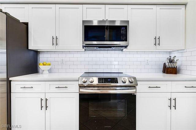 kitchen with white cabinets, appliances with stainless steel finishes, light countertops, and decorative backsplash