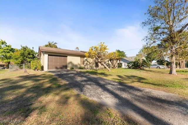 view of front of property with a front yard, fence, a garage, and driveway