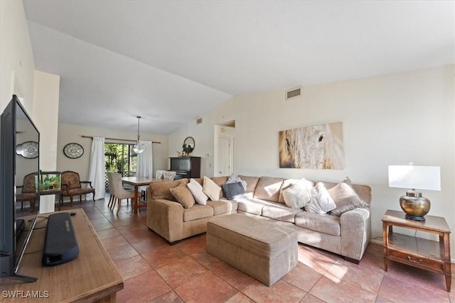 living area featuring visible vents, lofted ceiling, and light tile patterned flooring