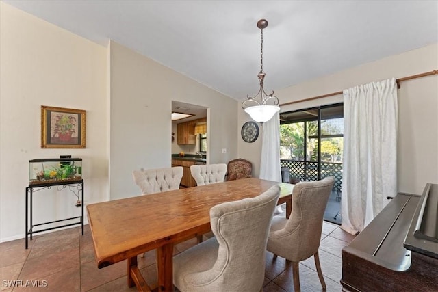 dining area featuring lofted ceiling and light tile patterned flooring