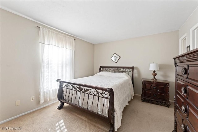 bedroom featuring light carpet and baseboards