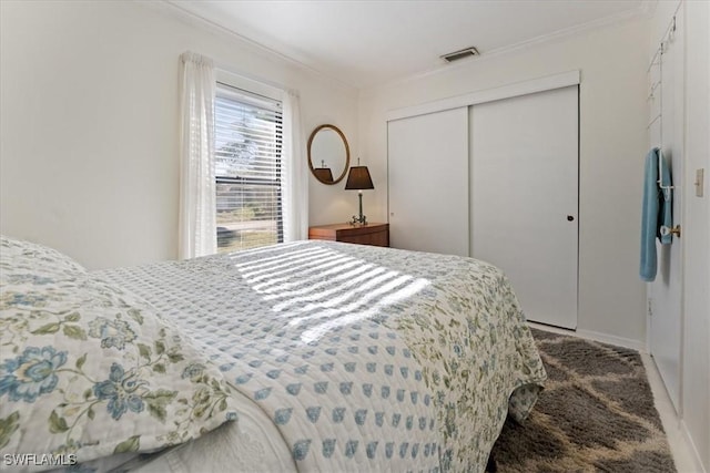 bedroom featuring visible vents, a closet, and ornamental molding