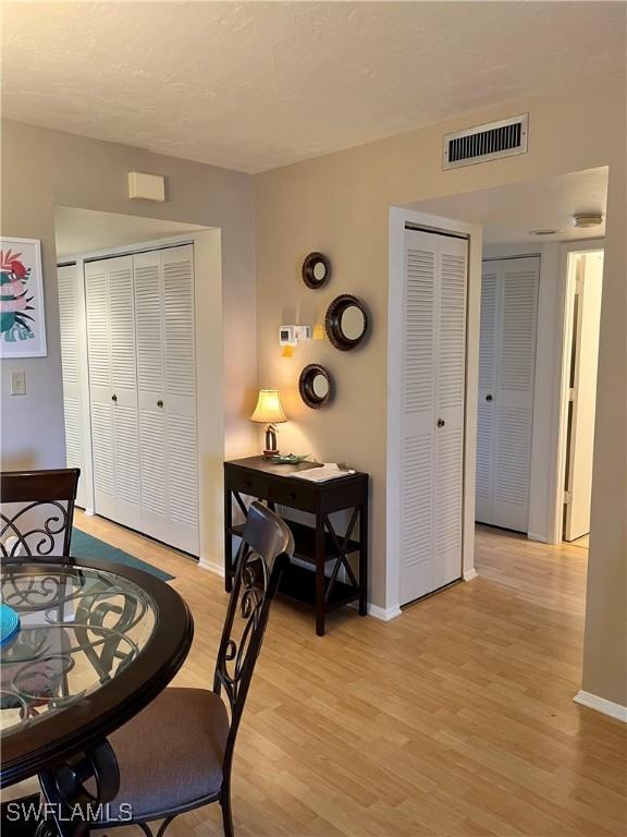 dining room featuring light wood finished floors, baseboards, and visible vents