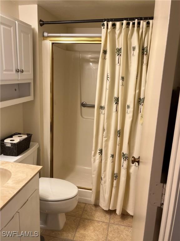 full bathroom with toilet, a shower stall, tile patterned flooring, and vanity