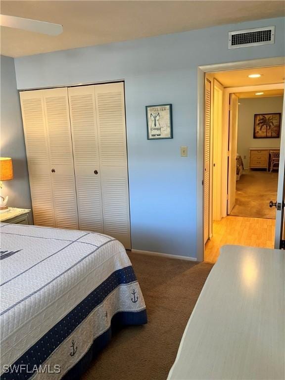 bedroom with a closet, visible vents, and light carpet