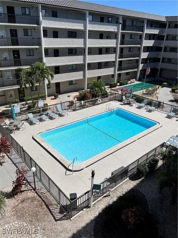 community pool with a patio area and fence