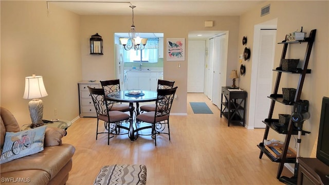 2121 Collier Ave Unit 405, Fort Myers, FL 33901 - dining area with an inviting chandelier, baseboards, light wood-style floors, and visible vents
