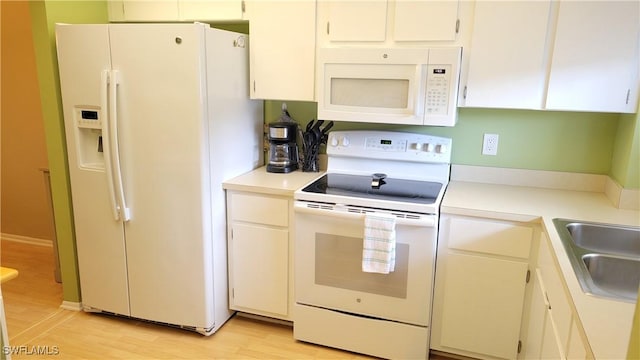 2121 Collier Ave Unit 405, Fort Myers, FL 33901 - kitchen featuring light countertops, light wood finished floors, white appliances, white cabinetry, and a sink