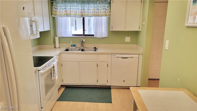 2121 Collier Ave Unit 405, Fort Myers, FL 33901 - kitchen featuring white cabinetry, light countertops, white appliances, a sink, and light wood-style flooring
