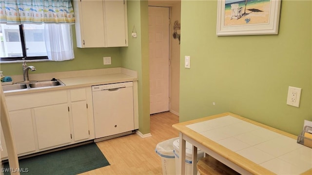 2121 Collier Ave Unit 405, Fort Myers, FL 33901 - kitchen featuring white cabinets, light countertops, light wood finished floors, dishwasher, and a sink
