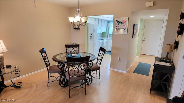 2121 Collier Ave Unit 405, Fort Myers, FL 33901 - dining room featuring baseboards, light wood-style flooring, and an inviting chandelier