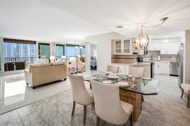 dining area with visible vents, a chandelier, and floor to ceiling windows