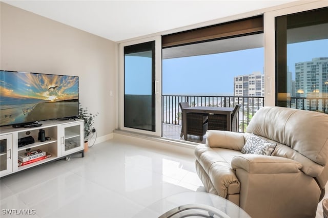 tiled living room featuring baseboards, a city view, and floor to ceiling windows