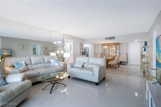 living room featuring light tile patterned floors, visible vents, and an inviting chandelier