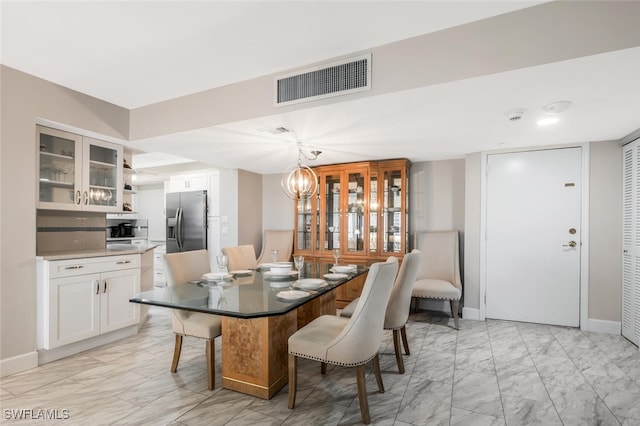 dining area featuring visible vents, baseboards, a notable chandelier, and marble finish floor