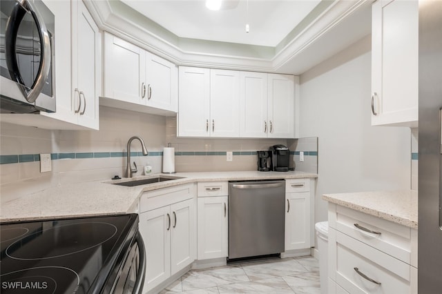 kitchen featuring tasteful backsplash, appliances with stainless steel finishes, marble finish floor, white cabinetry, and a sink