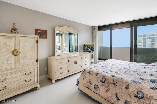 bedroom featuring access to outside, multiple windows, baseboards, and light tile patterned floors