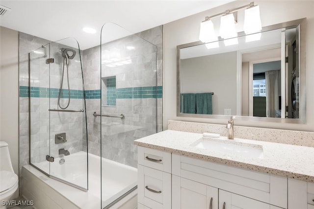 full bathroom featuring combined bath / shower with glass door, visible vents, toilet, and vanity