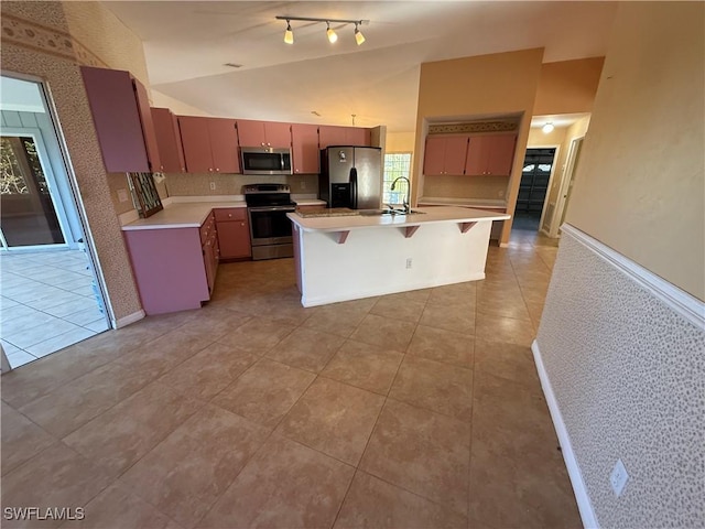 kitchen with light tile patterned floors, stainless steel appliances, light countertops, an island with sink, and a kitchen breakfast bar