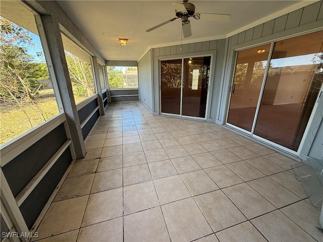 unfurnished sunroom featuring a ceiling fan