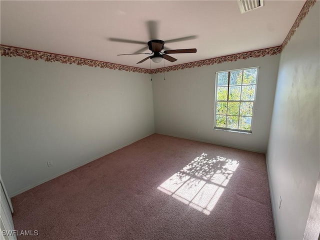 carpeted spare room with ceiling fan and visible vents