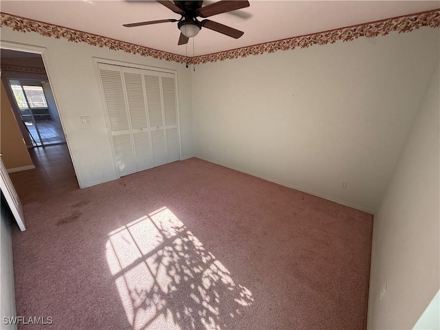 unfurnished bedroom featuring ceiling fan, a closet, and carpet